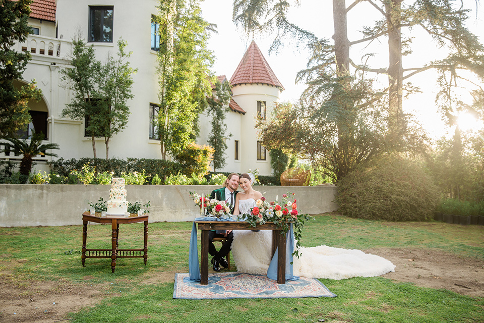  a dreamy whimsical wedding at a castle venue with the groom in a green velvet coat and the bride in a ballgown – sweetheart table 