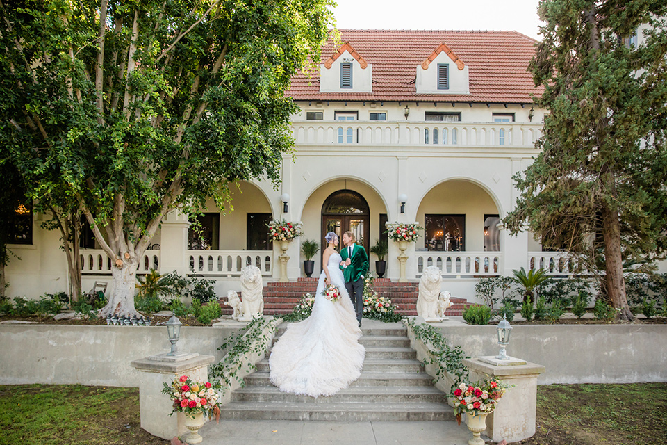  a dreamy whimsical wedding at a castle venue with the groom in a green velvet coat and the bride in a ballgown – walking down the aisle 