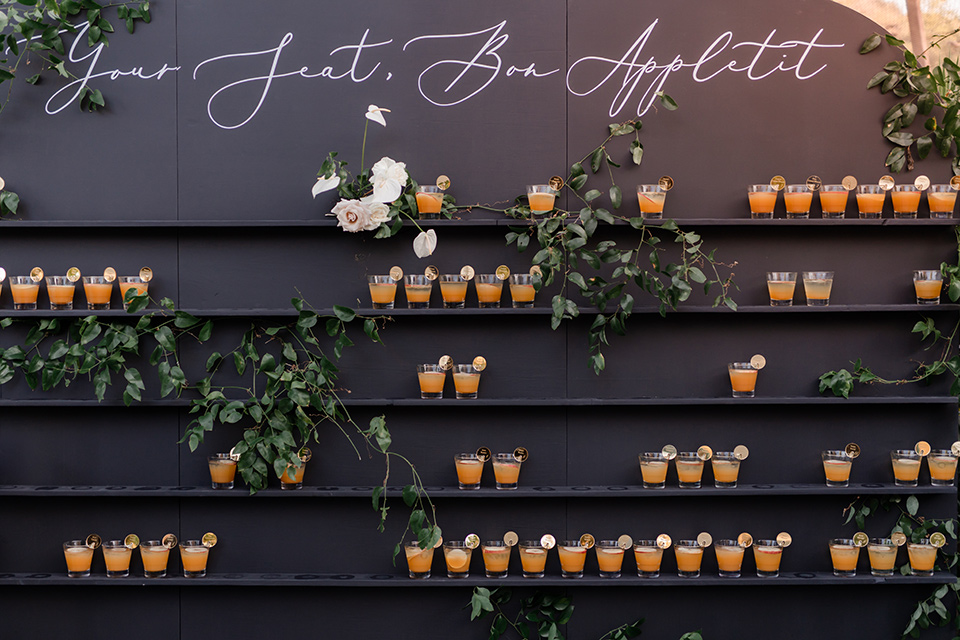  moody black and green wedding with neutral accents - cocktail wall 