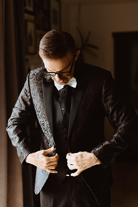  moody black and green wedding with neutral accents - groom in black 